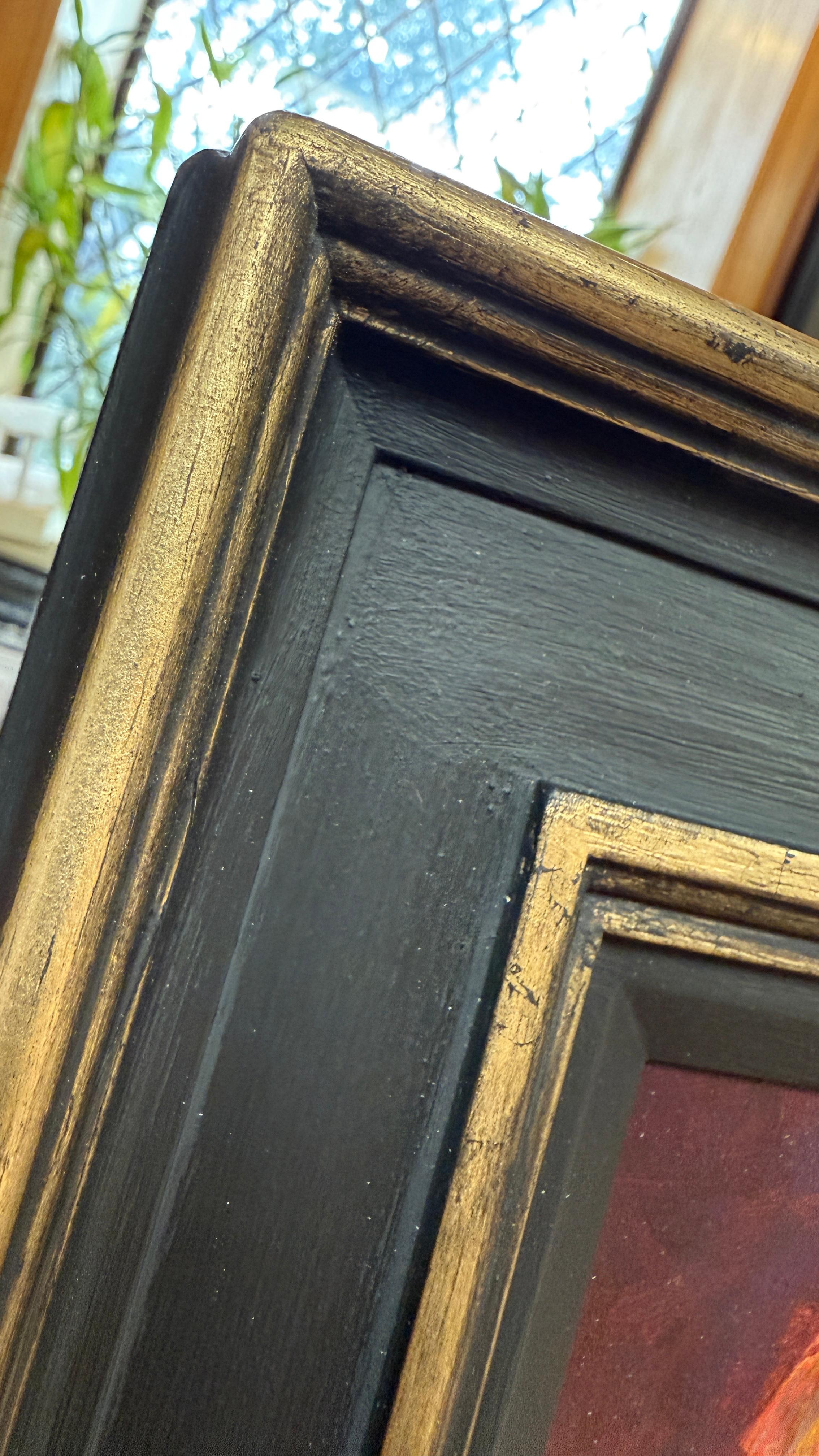 Frame close up of an oil painting of Two pears on a red surface with a dark background.